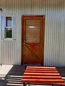 a red bench sitting in front of a door at Bungalows Estacion El Molino in San José