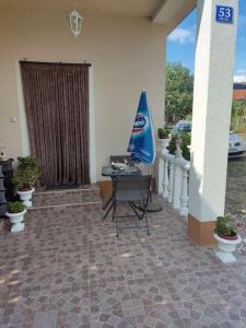 Dražice的住宿－Apartman David-Dražice，一个带桌子和蓝伞的庭院