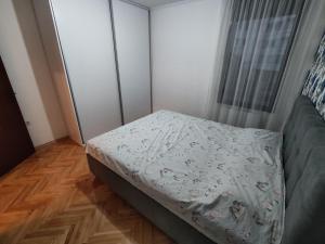 a small bedroom with a bed and a window at Apartment Alex in Banja Luka +5 photos