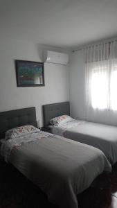 1 dormitorio con 2 camas y ventana en La Casa de Vicente y Soledad, en Ruidera