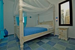 - une chambre avec un lit à baldaquin et un miroir dans l'établissement Ethereal Apartments, à Agrari