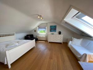 Schlafzimmer im Dachgeschoss mit 2 Betten und einem Fenster in der Unterkunft Apartment Art in Bad Krozingen