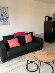 - un salon avec un canapé noir et 2 tables dans l'établissement SUPERBE APPARTEMENT FACE AUX ILES SANGUINAIRES, à Ajaccio