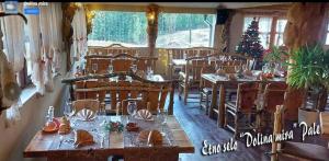 a restaurant with wooden tables and chairs and a christmas tree at Apartman Romanija Dolina mira in Pale