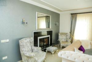a living room with a couch and chairs and a fireplace at Hot tub-Fireplace-Pets-Sleeps 11-Bbq-Pool-Parking in Dalyan