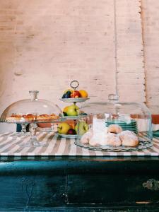 un buffet con pan y fruta en recipientes de vidrio en Dandelion Como Suites & Park, en Villa Guardia