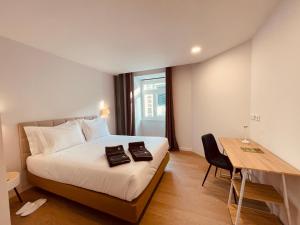 a bedroom with a bed and a table and a desk at Living Funchal Executive in Funchal