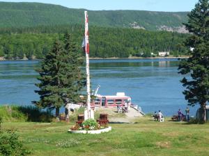 un poste con una bandera sobre un cuerpo de agua en Mountain Vista Seaside Cottages, en Big Bras d'Or