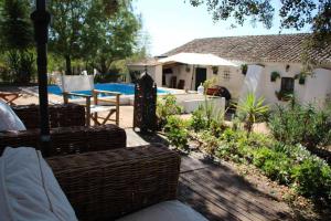 eine Terrasse mit zwei Korbstühlen und einem Haus in der Unterkunft Casa das Moles in Évora