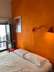 ein Schlafzimmer mit einem Bett mit einer orangefarbenen Wand in der Unterkunft Dependace il David di Michelangelo in Florenz