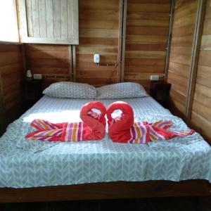 a bed with two pairs of towels on it at Finca Sueno de Osa in Puerto Jiménez