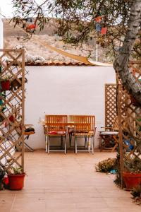 een patio met 2 banken en een tafel en stoelen bij Alma Libre Guest House in Guatiza
