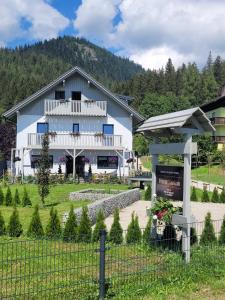 uma casa branca com uma cerca à frente. em Haus Karina em Bad Mitterndorf