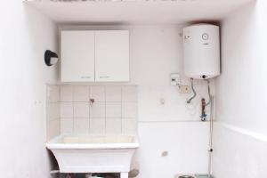 biała łazienka z umywalką i toaletą w obiekcie Cómodo PH con patio propio w BuenosAires