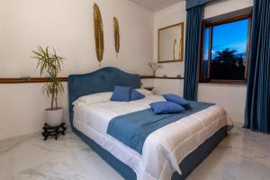 Schlafzimmer mit einem Bett mit blauer und weißer Bettwäsche in der Unterkunft Villa Edelweiss in Bacoli