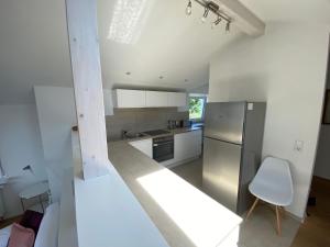 een keuken met een roestvrijstalen koelkast en een witte stoel bij Apartment Art in Bad Krozingen