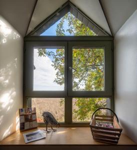 a large window in a room with a bird on a table at La Ligne in Angles-sur-lʼAnglin