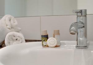 a bathroom sink with three bottles of cosmetics on it at Crown Apartments 113 by Week2Week in Newcastle upon Tyne
