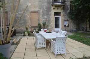 una mesa blanca y sillas en un patio en MAS DE LA FORGE NOGUIER, en Vergèze