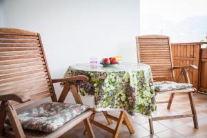 a table with two chairs and a table with fruit on it at Bbmarlene in Bolzano