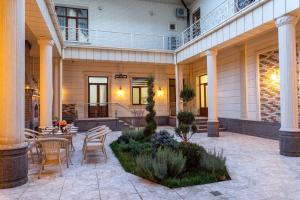 Un patio con una mesa y sillas en un edificio. en Osiyo Plaza Hotel, en Samarkand