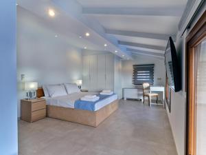 a bedroom with a bed and a desk and a television at Forecastle in Keratea +63 photos