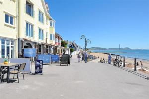 a street with tables and chairs and people on the beach at Starfish in Lyme Regis