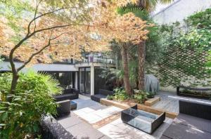ein Innenhof mit Bänken und Bäumen in einem Gebäude in der Unterkunft Villa Alesia in Paris