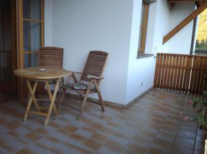 una camera con un tavolo e due sedie su un balcone di Bbmarlene a Bolzano
