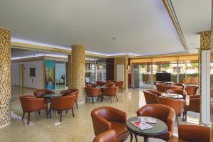 a waiting room with chairs and tables and a tv at Zel Hotel in Antalya