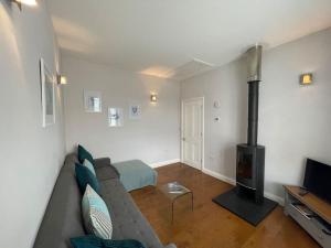 a living room with a couch and a fireplace at Fuchsia Cottage in Flushing