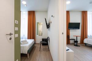 a hotel room with a bed and a television at Camplus Guest Bernini Casa per Ferie in Turin