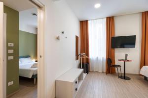 a hotel room with a television and a bed at Camplus Guest Bernini Casa per Ferie in Turin