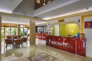 a restaurant with a red reception counter and chairs at Zel Hotel in Antalya