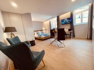 sala de estar con 2 sillas, 1 cama y 1 sofá en Living Funchal Executive en Funchal