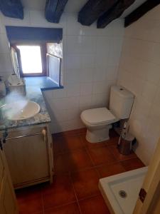 uma casa de banho com um WC, um lavatório e uma janela em Cabaña Pasiega La Quemada em San Pedro del Romeral