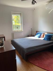 ブダペストにあるRoseHill Garden Villaのベッドルーム1室(青い枕のベッド1台、窓付)