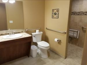 a bathroom with a toilet and a sink and a shower at Terrace Park Inn in Fort Morgan