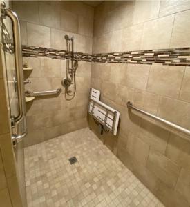 a bathroom with a shower and a tiled floor at Terrace Park Inn in Fort Morgan