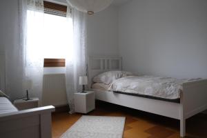 a white bedroom with a bed and a window at Ferienwohnung Casa Bella 