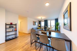 a dining room and living room with a table and chairs at Modernes Stadtapartment mit Terrasse in Vienna