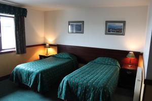 A bed or beds in a room at The Weigh Inn Hotel & Lodges