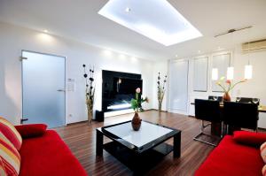 sala de estar con sofá rojo y mesa en Apartment Giuliano Vienna, en Viena