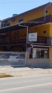un edificio amarillo con una valla blanca delante de él en Pousada Rota do Parque, en Penha