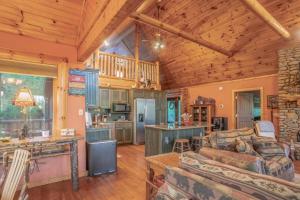 een woonkamer met een bank en een tafel bij Smoke Rise Lodge · Lake Front, Luxury Cabin, Hot Tub, in Dandridge