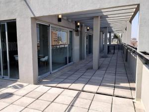 an empty balcony of a building with glass windows at Mono Quality - laundry, coworking, pileta y SUM in San Miguel de Tucumán