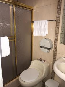 y baño con ducha, aseo y lavamanos. en Hotel Pegazus, en Guayaquil