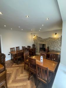 a dining room with wooden tables and chairs and a fireplace at The Black Horse Inn in Settle