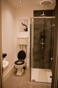 a bathroom with a toilet and a glass shower at The Black Horse Inn in Settle