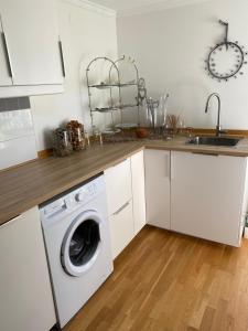 a kitchen with a washing machine and a sink at Röda huset in Hallstahammar